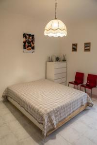 a bedroom with a bed and two red chairs at Casa Frida in Roccagloriosa