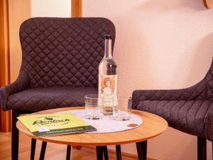 a bottle of wine on a table next to two chairs at Hotel Gerlach in Ürzig