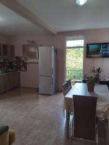 a kitchen with a table and a refrigerator at E L A in Kobuleti