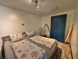 a bedroom with two beds and a blue cabinet at Ferienhaus AUEN mit Seezugang in Velden am Wörthersee
