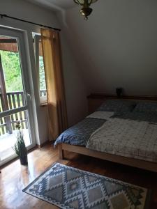 a bedroom with a bed and a window and a rug at Zielony Zakątek in Łubno