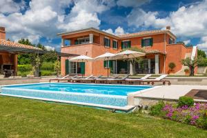 a house with a swimming pool in the yard at Beautiful Villa Village with tennis court in Tinj in Tinjan