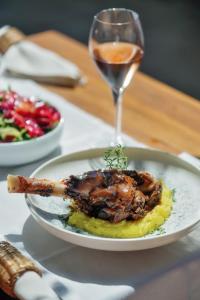 a plate of food on a table with a glass of wine at Kassandra Boutique Hotel in Oludeniz