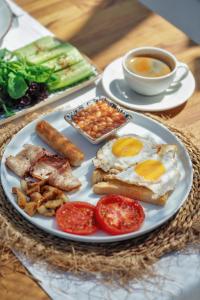 a plate of breakfast food with eggs sausage beans and tomatoes at Kassandra Boutique Hotel in Oludeniz