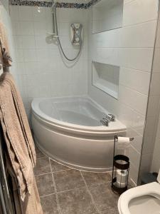 Un baño blanco con bañera y inodoro. en The Bijou on Park View, en Harrogate 4 fotos más