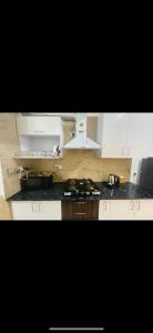a kitchen with white cabinets and a stove top oven at Wanderers inn- beautiful hills view in Dehradun +29 photos