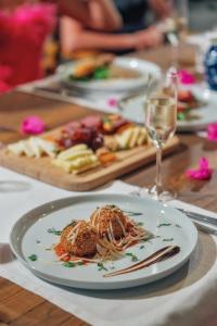 a table with a plate of food and a glass of wine at Kassandra Boutique Hotel in Oludeniz