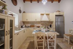 a kitchen with a table with chairs and a refrigerator at Villa Oros in StrinÃ½las