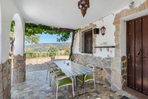 Una mesa y sillas en un patio con vista. en La Casita, en Ronda