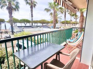 Un balcón con mesa y sillas y una piscina. en T2 BORD DE MER vue plages WIFI climatisé parking inclus, en La Ciotat