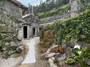 una casa de piedra con un camino delante de ella en Mirada Do Roxo, en Oia