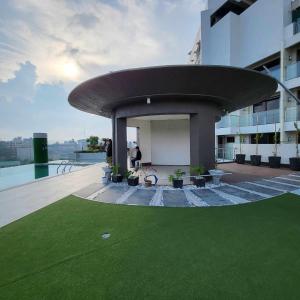 碧瑶Modern 1Bedroom Condo,with heated Roofdeck pool by Mist and Pine的一座有圆形屋顶和绿草的建筑