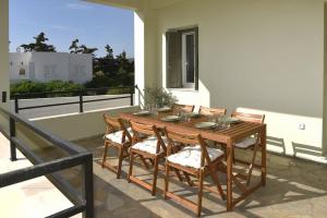 a wooden table and chairs on a balcony at Krios Summer Stay in Ermoupoli