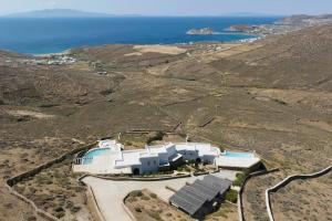 een luchtzicht op een gebouw op een heuvel met de oceaan bij Villa Calithenean in Mykonos-stad