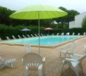 una piscina con sillas y una gran sombrilla verde en L'Intimate Sahara - Piscine - Tennis - Clim, en Cap d'Agde 10 fotos más