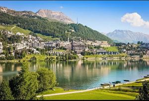 a view of a lake with a town and mountains at St Moritz Suite in St. Moritz
