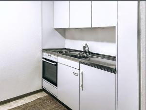a kitchen with white cabinets and a sink at St Moritz Suite in St. Moritz