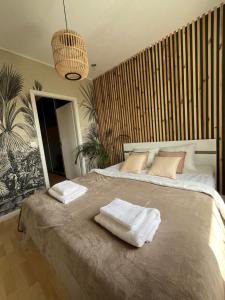 a bedroom with a large bed with towels on it at Colorado in Gdańsk