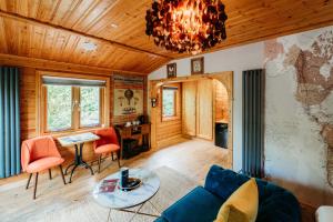a living room with a couch and a chandelier at Bazare Log Cabin, Whinstone View in Great Ayton