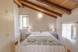 a bedroom with a white bed with two chairs at Villa Oros in StrinÃ½las