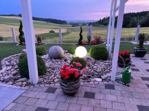 a garden with red flowers in a stone pathway at Ferienwohnung mit herrlicher Aussicht "Ihre Urlaubs-Oase auf Zeit!" in Bad Dürrheim
