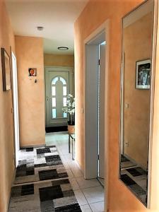 a hallway with orange walls and a mirror at Ferienwohnung mit herrlicher Aussicht "Ihre Urlaubs-Oase auf Zeit!" in Bad Dürrheim +14 photos