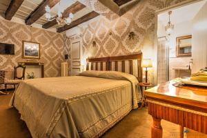 a bedroom with a bed and a table and a piano at Residenza Corte Molin in Venice