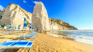 a group of beach chairs and umbrellas on a beach at Acqua Marina casa vacanza in Vieste