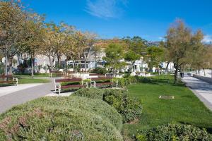 a park with benches and bushes and trees at Apartment Beba in Kaštela
