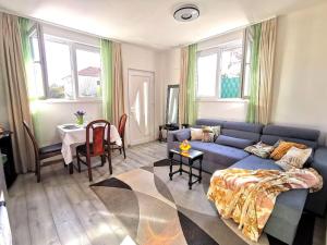 a living room with a blue couch and a table at Apartment Beba in Kaštela