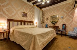 a bedroom with a large bed and two chairs at Residenza Corte Molin in Venice