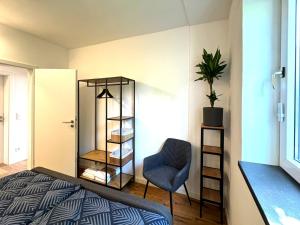 a bedroom with a bed and a chair and a shelf at Ferienhaus Ahaus in Ahaus