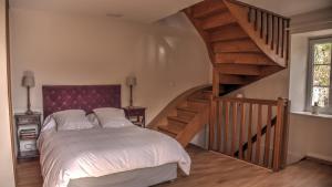 a bedroom with a large bed and a staircase at Maison Melrose in Vouvray