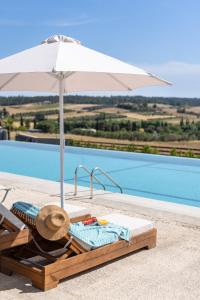 a lounge chair with an umbrella next to a pool at Sani Gulf I & II in Sani Beach