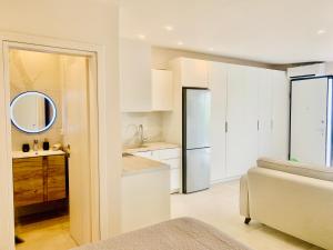 biała kuchnia ze zlewem i lodówką w obiekcie Thelfi Luxury studio in Attica - close to varkiza beach - Sea view w mieście Vari