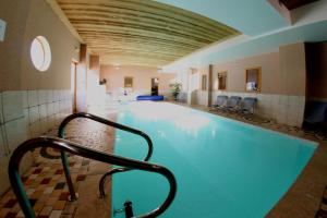 a swimming pool with a hand rail in a building at Chalet des Neiges Oz en Oisans in Oz