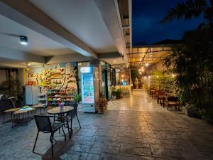 a patio with chairs and tables in a building at night at Le Neuf Nakorn Lampang in Lampang