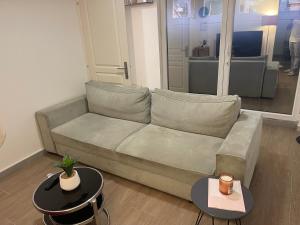 - un salon avec un canapé et deux tables dans l'établissement La girafe, à Sannois