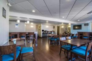a dining room with wooden tables and blue chairs at Comfort Inn & Suites South in Calgary