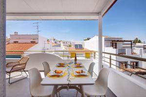 a table on a balcony with a view of the city at Flor de Sol House in Tavira
