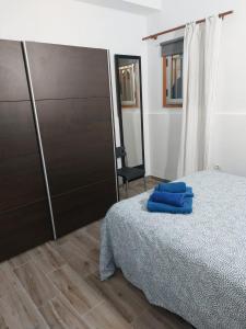 a bedroom with a bed with blue towels on it at Vista Puerto Ground Floor No Balcon in Arguineguín