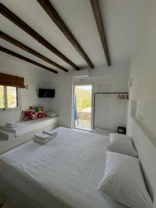 Habitación blanca con cama grande y pantalla en Manthos Place, en Mylopotas 110 fotos más