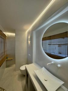 Un baño con un inodoro blanco y un espejo. en Manthos Place, en Mylopotas