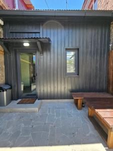a wooden building with a bench and a window at Gyumri House Kentron in Gyumri