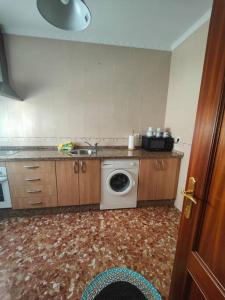 a kitchen with a washing machine and a sink at Apartamento corrales in Chipiona