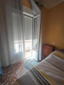 a bedroom with a bed and a large window at Apartamento corrales in Chipiona +8 photos