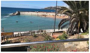 a beach with people swimming in the water at Vista Puerto Ground Floor No Balcon in Arguineguín