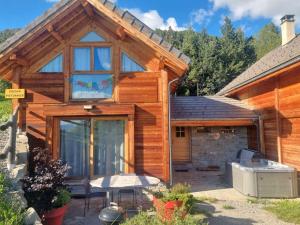 une cabane en rondins avec une table de pique-nique devant elle dans l'établissement Chalet 6 pers avec SPA, terrasse plein sud à Saint-Michel-de-Chaillol - FR-1-393-22, à Saint-Michel-de-Chaillol