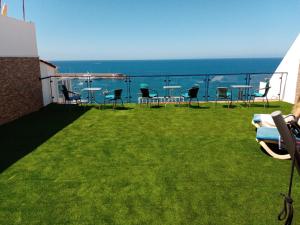 a balcony with chairs and tables and the ocean at Vista Puerto Ground Floor No Balcon in Arguineguín +9 photos