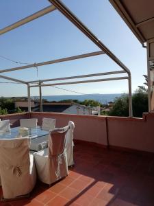 a patio with a table and chairs on a roof at Torre del Pozzo Seaview Retreat Sunset Terrace in S'archittu Cuglieri